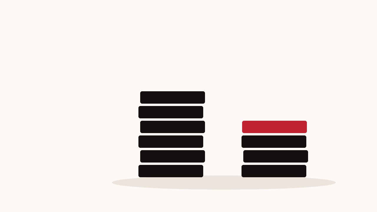 Two stacks of black paper cards on a cream surface, one stack taller, with a single red card standing on the shorter stack
